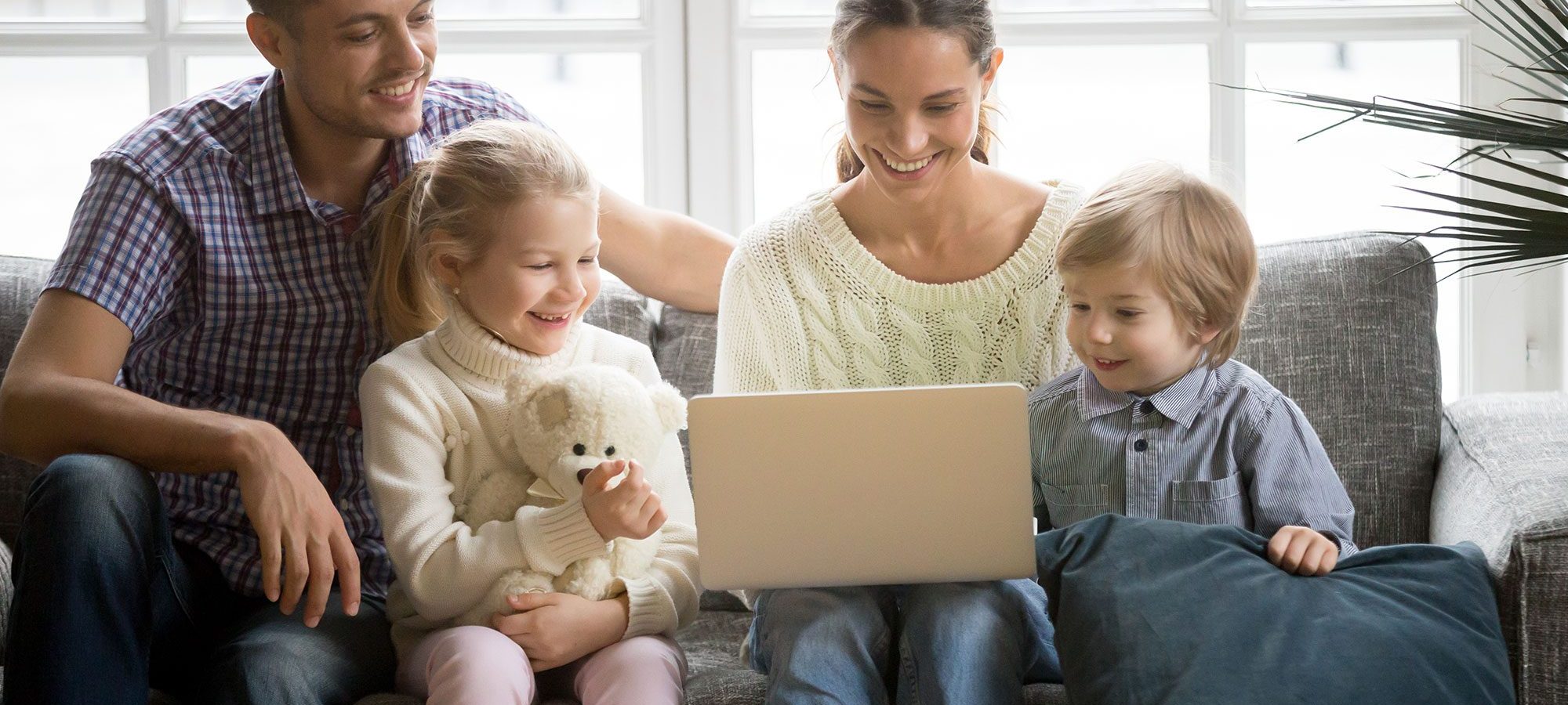 happy-family-with-children-having-fun-using-laptop-sofa